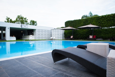 Una piscina al aire libre de temporada, sombrillas