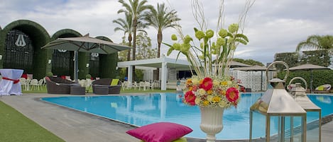 Een seizoensgebonden buitenzwembad, parasols voor strand/zwembad