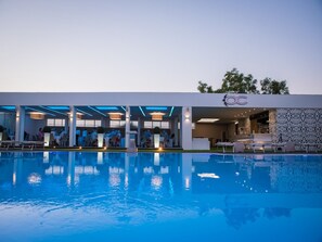 A modern hotel with a pool, outdoor seating, and a bar area. - Hotel Giulia Ocean Club (Qualiano)