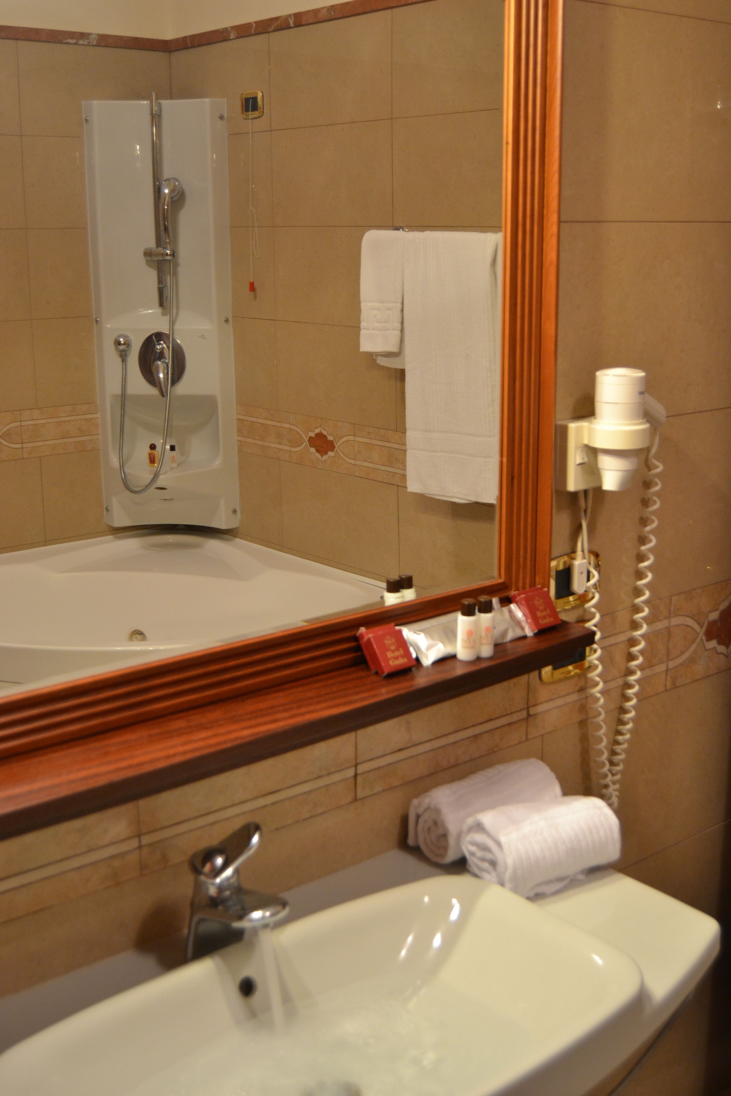Un baño con lavamanos, espejo y ducha.