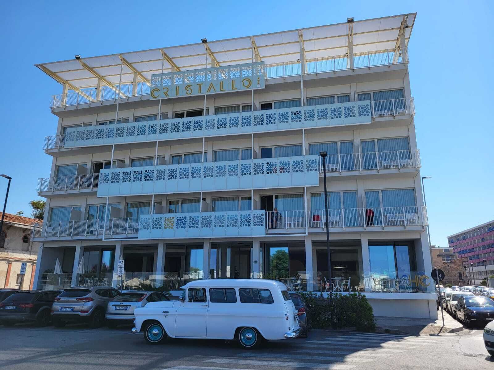 Un hotel de varios pisos con balcones y una entrada cubierta.
