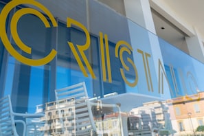 Un edificio con la palabra 'CRISTAL' en letras grandes en la fachada.