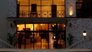 A multi-story building with a large arched window and a lower ground-floor entrance. - The Cliff Beach & SPA Hotel (Obzor)