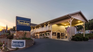 Een Travelodge motel met een twee verdiepingen hoge structuur, een overdekte ingang en een vlag.