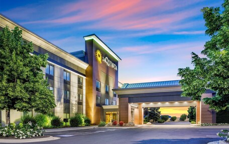 A modern hotel with a prominent 'La Quinta' sign, a covered entrance, and well-maintained landscaping.