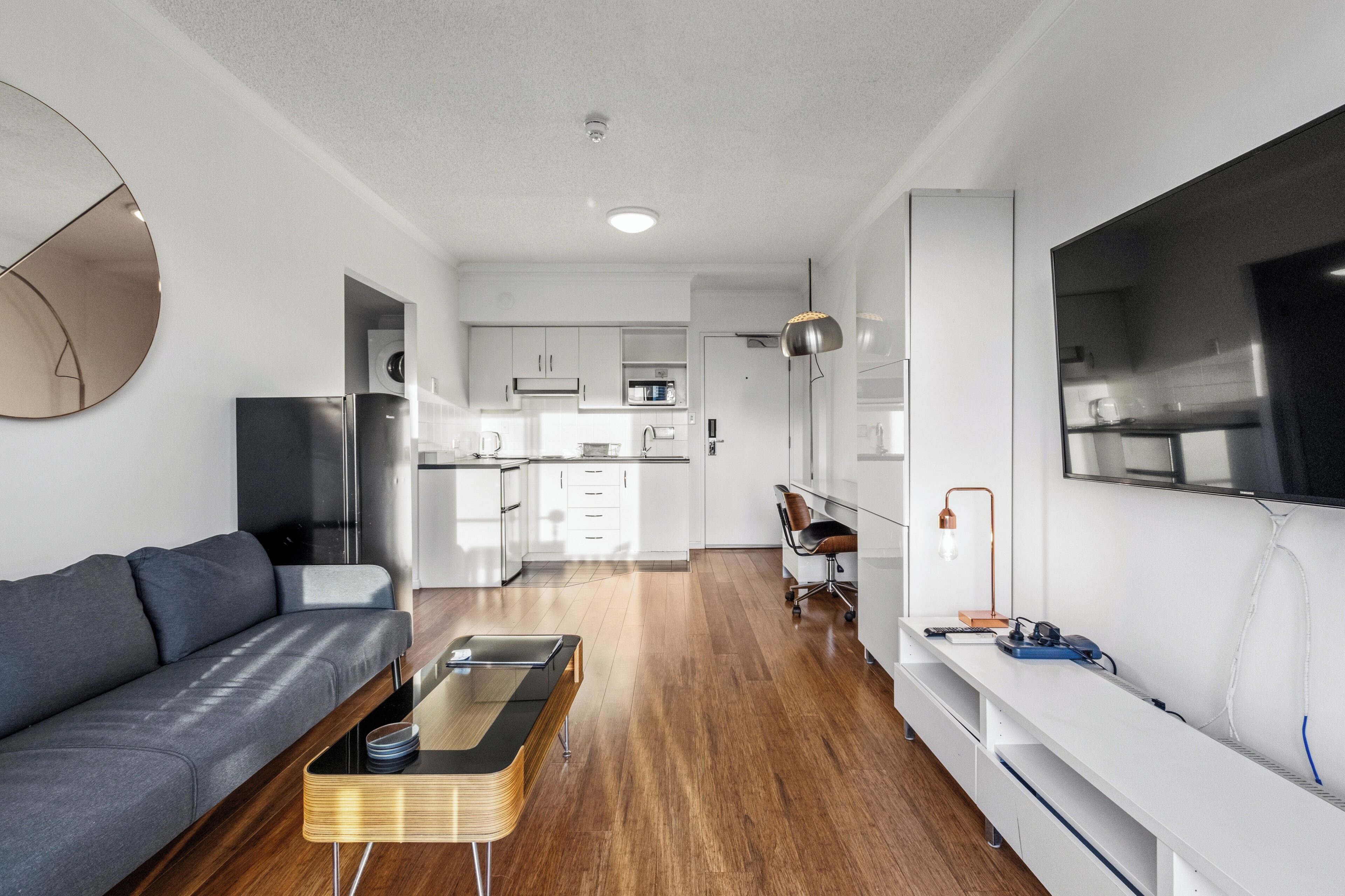 A modern living room with a sofa, coffee table, and TV.