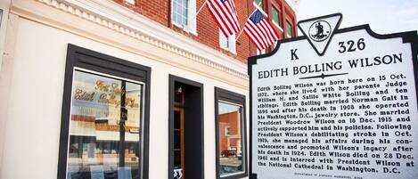 Ein historisches Schild für Edith Bolling Wilson vor einem Gebäude mit amerikanischen Flaggen.