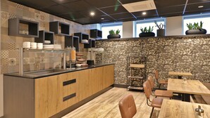 Interior moderno de restaurante con mostrador de madera, zona de estar y azulejos decorativos.