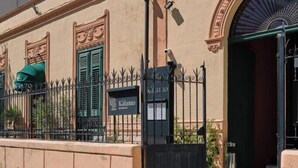 A building facade with a sign reading 'Kalamon Restaurant,' a black gate, and a green awning. - Villa Scaduto Residence (Bagheria)