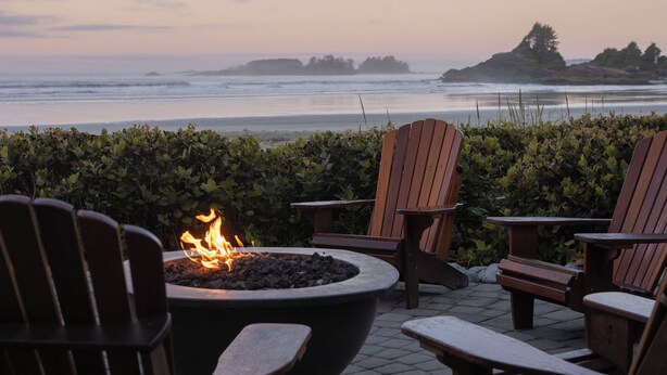 A patio with Adirondack chairs, a fire pit, and a view of the ocean. - Long Beach Lodge Resort (Tofino)