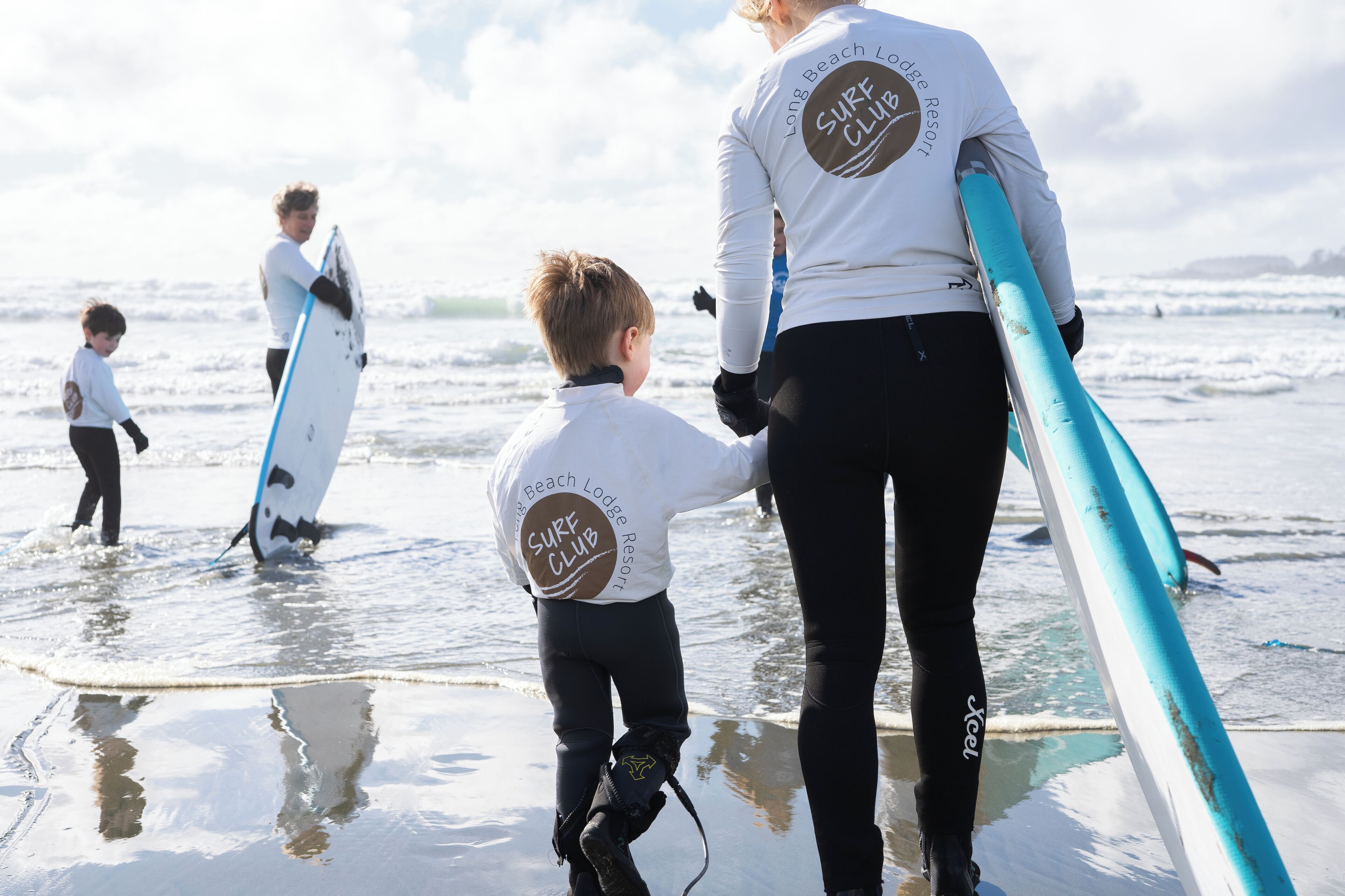 Un grup de persones amb taules de surf a la platja.