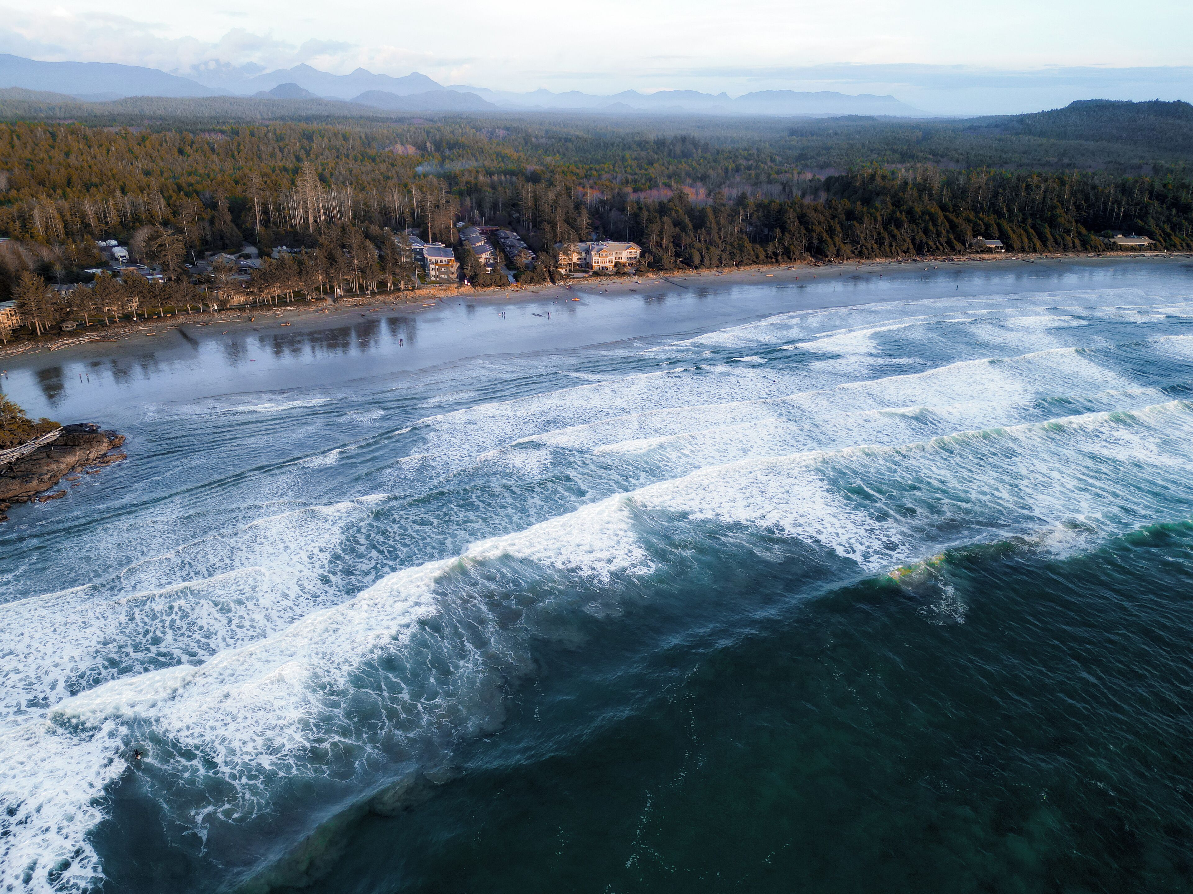 Un río con olas, rodeado de bosque y montañas.