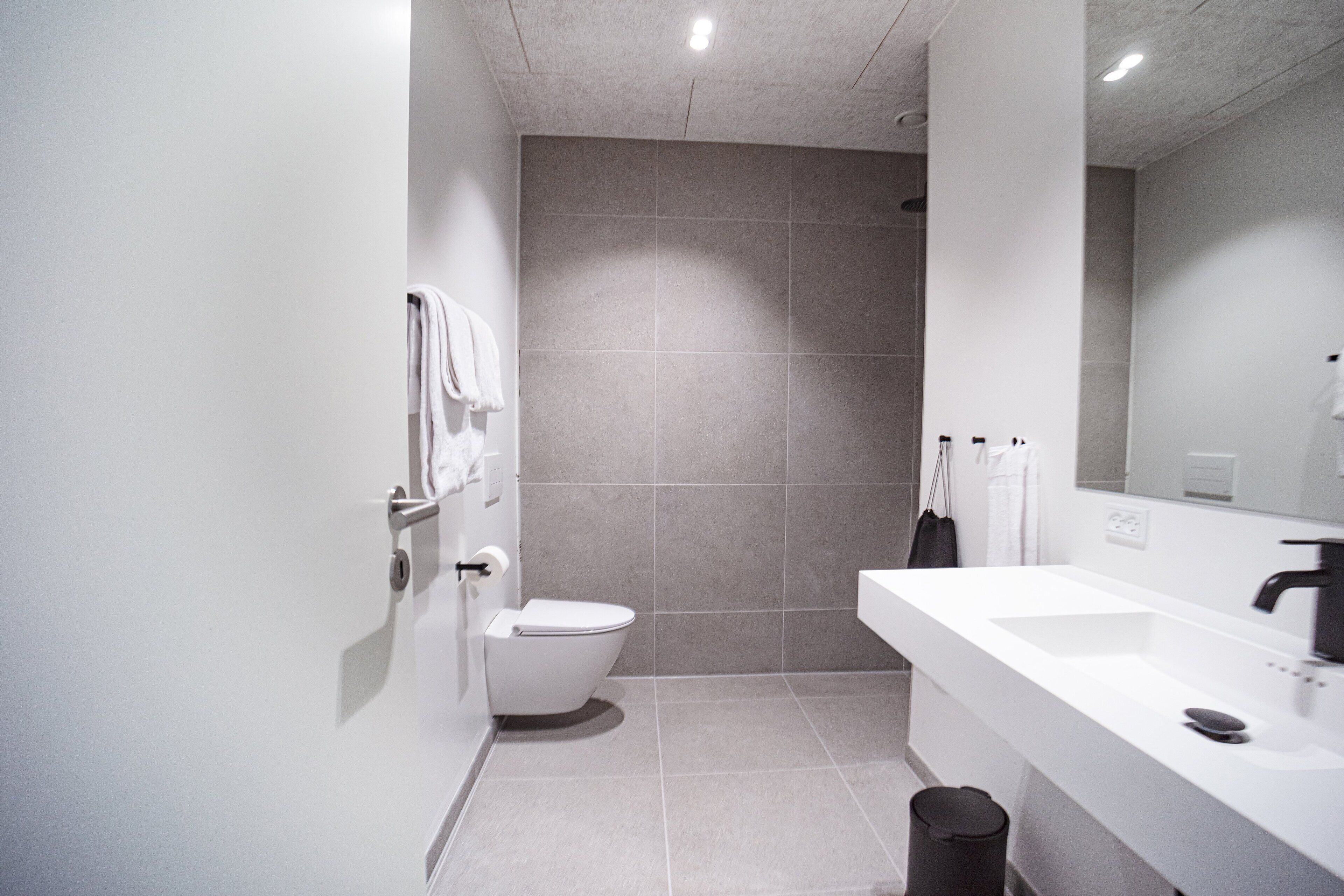 A modern bathroom with a toilet, sink, and shower area.