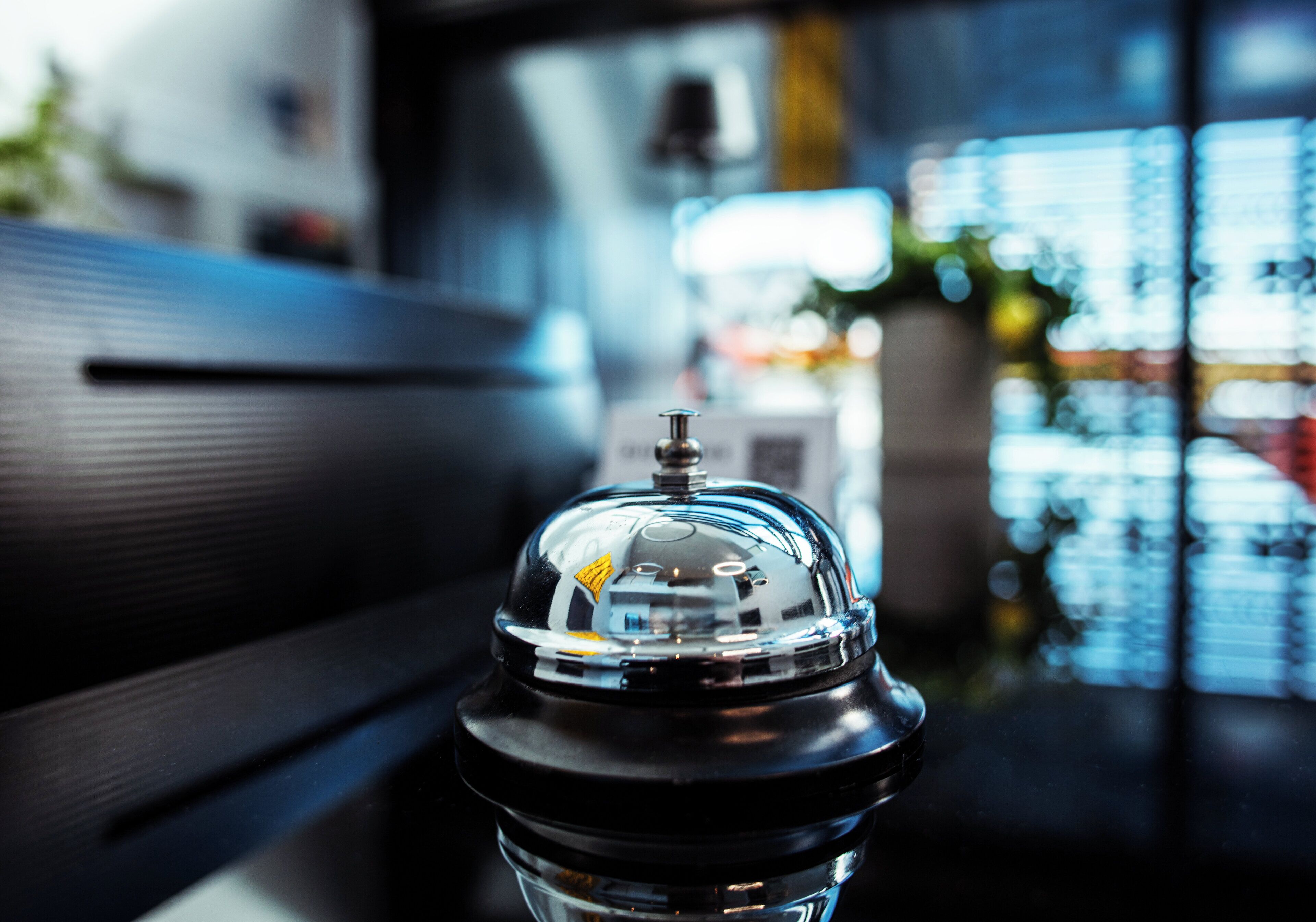 A close-up of a coffee machine with a reflective surface, placed on a table in a modern setting.