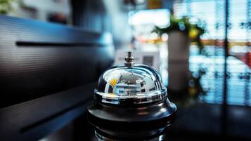 A close-up of a coffee machine with a reflective surface, placed on a table in a modern setting.