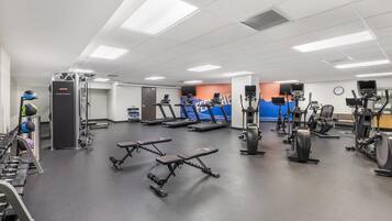 A gym with treadmills, elliptical machines, and weightlifting equipment.