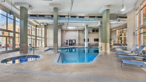An indoor swimming pool with lounge chairs, large windows, and a visible vending machine. - Bluegreen Vacations Club 36, an Ascend Collection Resort (Las Vegas)