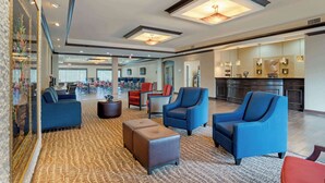 A spacious lobby with comfortable seating, a kitchen area, and a large mirror reflecting the space. - Comfort Suites Alexandria North (Alexandria)