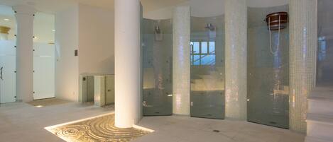 Eine großzügige Lobby mit einer Säule, einem gemusterten Teppich und einer Glaselevator.