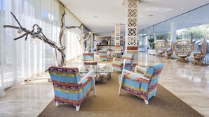 A spacious lobby with modern furniture, large windows, and a reception area. - Aparthotel Tropic Garden (Santa Eulalia del Rio)