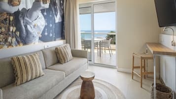 A living room with a sofa, a coffee table, and a large painting.