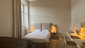 Une chambre d’hôtel avec un lit, un bureau, une chaise et un canapé.