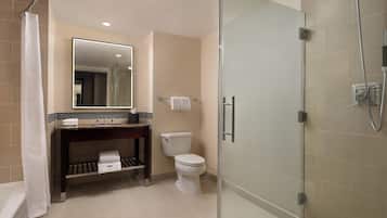 Une salle de bain moderne avec une douche à parois de verre, des toilettes, un lavabo avec un miroir et un porte-serviettes.