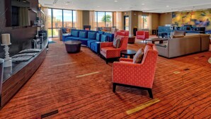 A spacious lobby with a mix of seating areas, a reception desk, and a large window offering a view of the outdoors. - Courtyard by Marriott Midland (Midland)