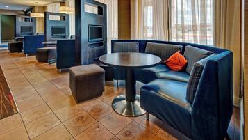 A modern hotel lobby with a sofa, ottoman, and round table.