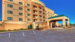 A Courtyard by Marriott hotel with a large parking lot and a covered entrance. - Courtyard by Marriott Midland (Midland)