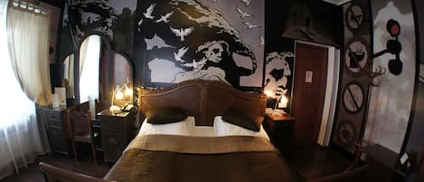 A room with a bed, a desk, a chair, and a mirror.