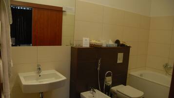 Un baño con lavamanos, bidé y bañera.