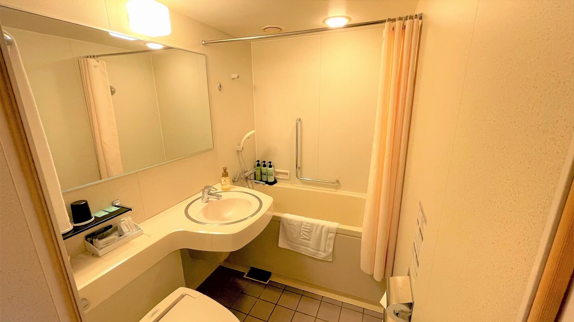 A bathroom with a sink, mirror, towel rack, and shower curtain.