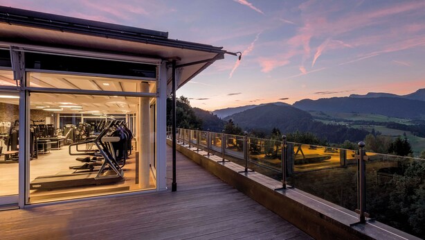Un gimnasio con equipo de ejercicio y una vista panorámica de la montaña.