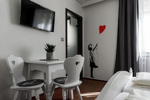 Habitación doble estándar, 1 cama King size | Área de sala de estar | Televisión de pantalla plana de 60 cm con canales por cable 