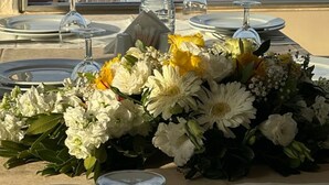A table set for dining with a city view, a water bottle, and a bouquet of flowers. - Sude Konak Hotel - Special class (Istanbul)