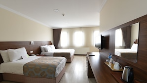 A hotel room with two beds, a desk with a mirror, a coffee maker, and a TV. - Asal Hotel (Ankara)