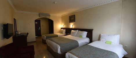 Une chambre d’hôtel avec deux lits, un bureau, une chaise et un téléviseur.