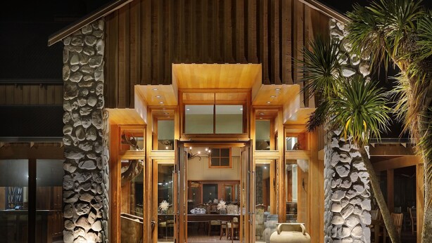 A modern building with a stone facade, large glass doors, and a wooden entrance. - Fable Terrace Downs Resort by Mgallery (Windwhistle)