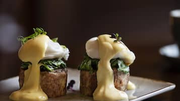 Deux assiettes contenant des œufs pochés et nappés de sauce hollandaise.
