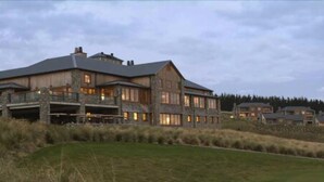 A large, multi-story building with a stone facade and multiple windows, surrounded by grassy fields and trees. - Fable Terrace Downs Resort by Mgallery (Windwhistle)
