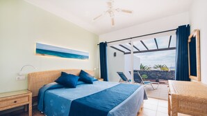 Une chambre à coucher avec un lit, une table de chevet, un bureau et une vue sur l’extérieur.