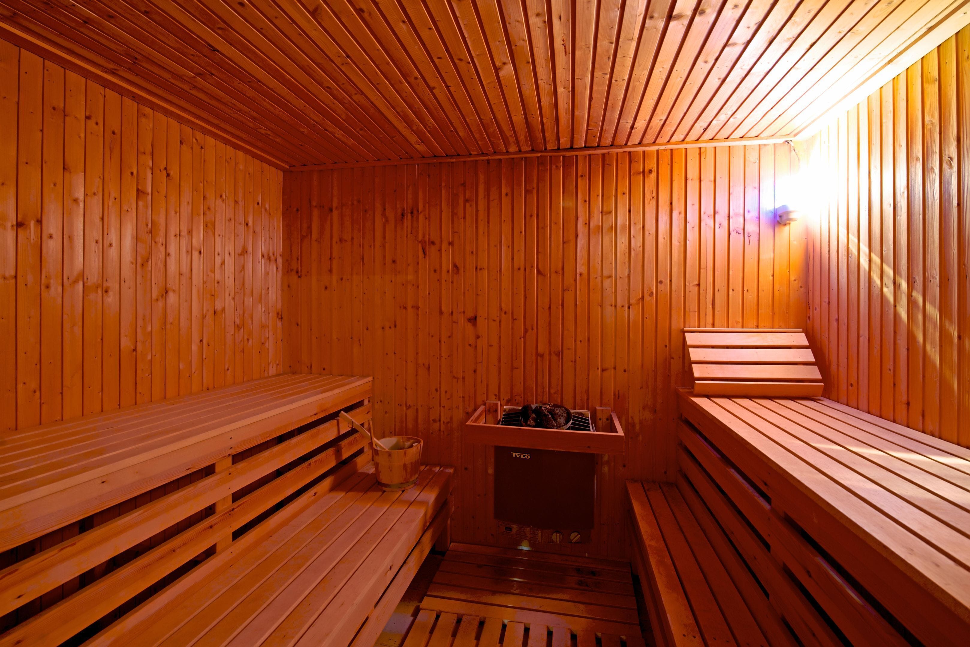 Uma sauna com bancos de madeira e unidade de aquecimento central.