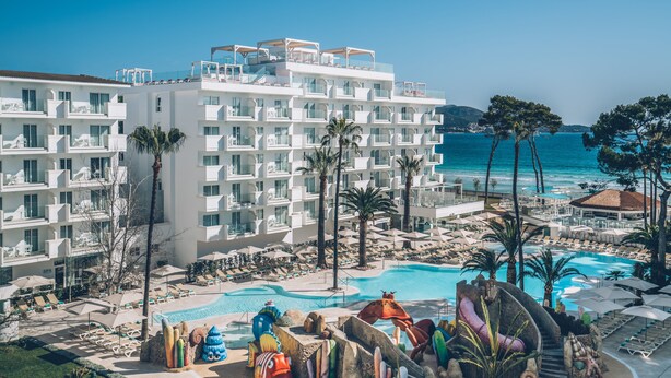 A resort with multiple balconies, a swimming pool, and a view of the sea. - Iberostar Waves Alcudia Park (Muro)