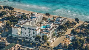 An aerial view of a coastal hotel with multiple buildings, a beach, and a pier. - Iberostar Waves Alcudia Park (Muro)