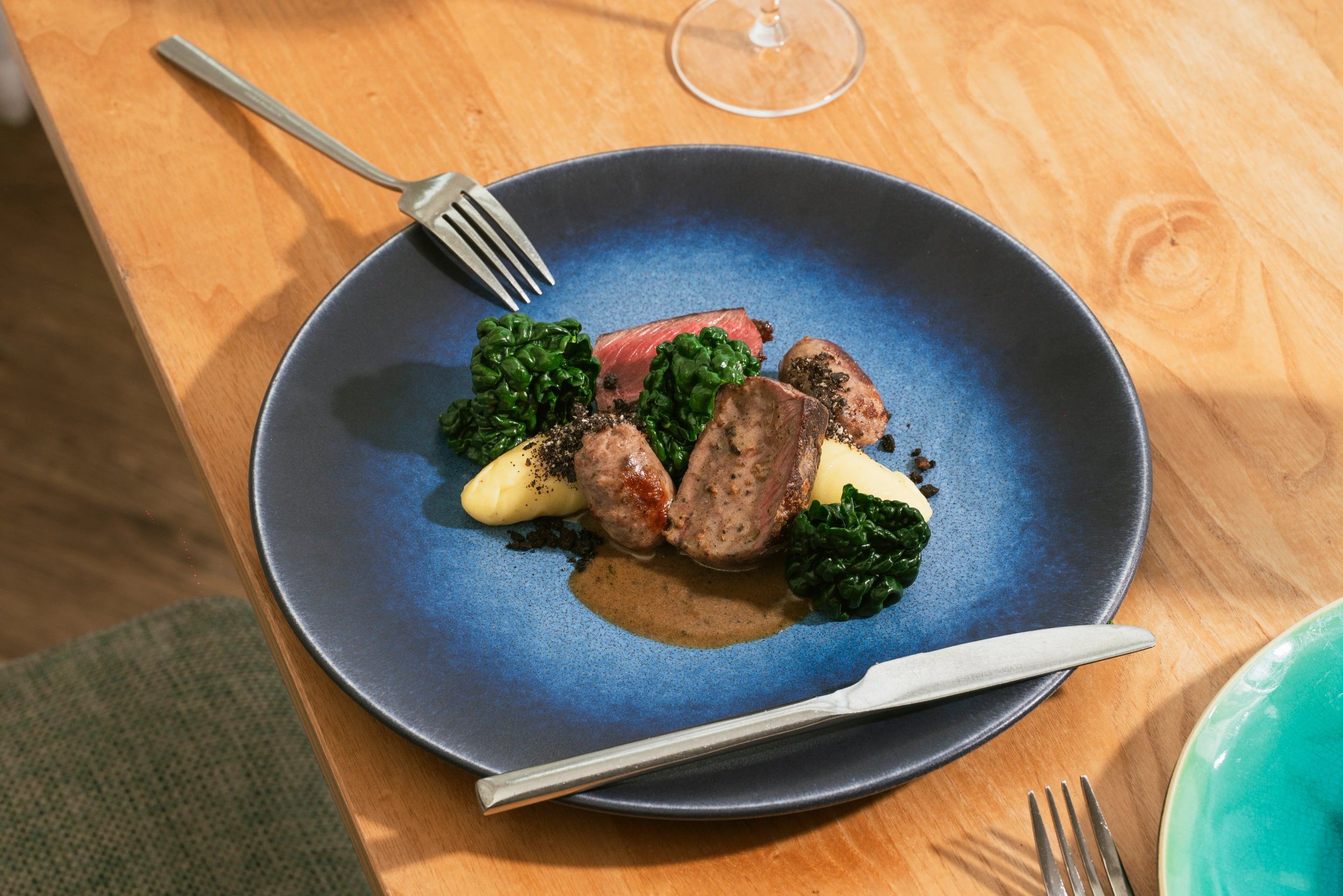 Un plato de comida con un tenedor sobre una mesa de madera.
