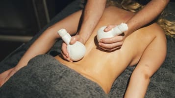 Uma pessoa recebendo massagem, com uma toalha cobrindo a parte inferior do corpo.