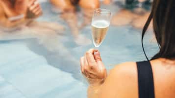 A person holding a glass of champagne in a pool.