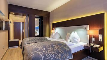 A hotel room with two beds, a bedside telephone, and a nightstand.