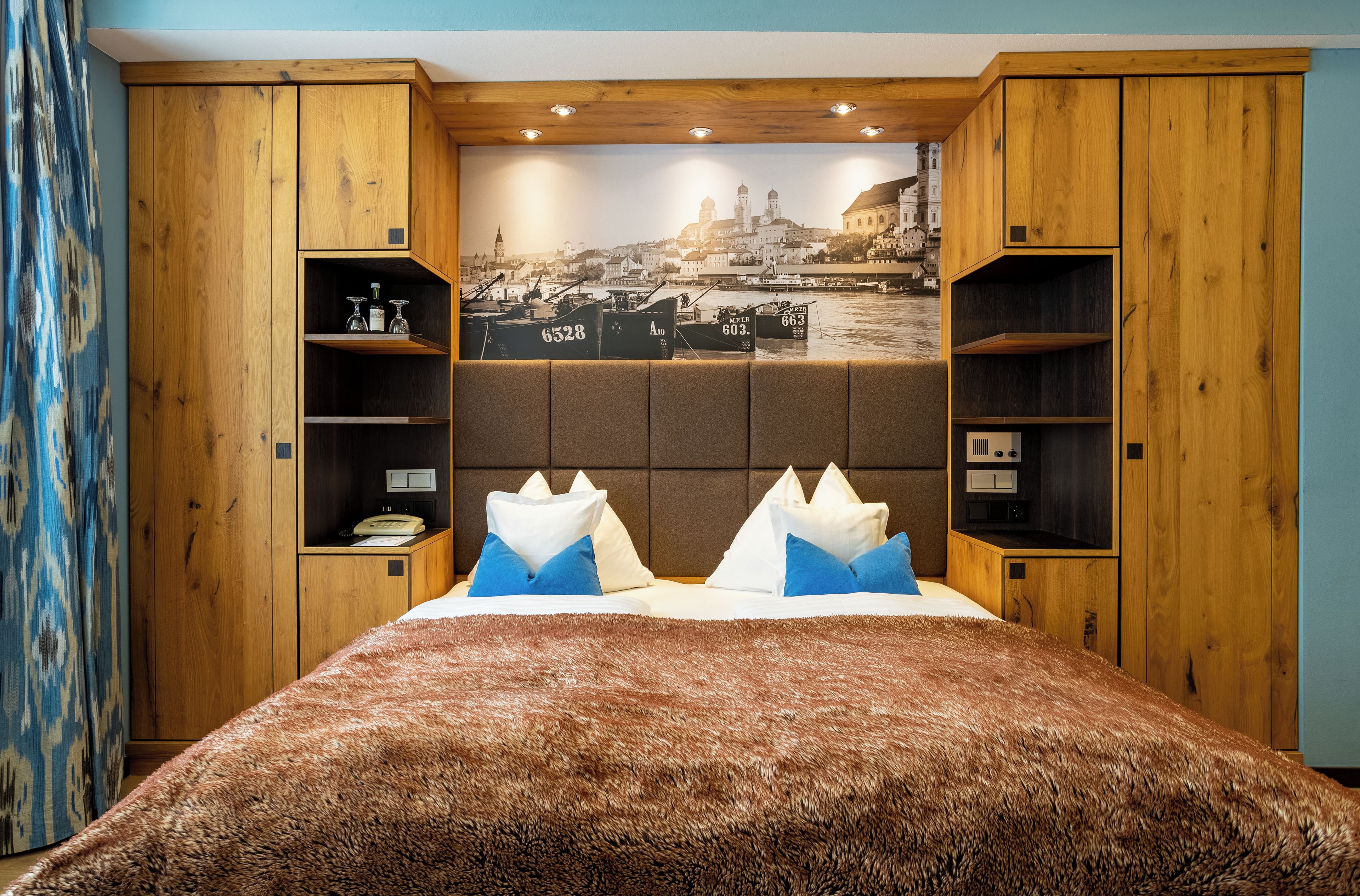 A bedroom with a large bed, wooden headboard, and built-in shelving.